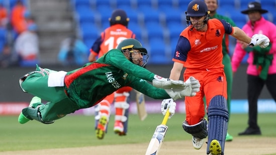 Nurul Hasan (L) dives to field the ball as Colin Ackermann completes a run during the T20 World Cup 2022 match between Bangladesh and Netherlands at Bellerive Oval in Hobart on October 24, 2022.(AFP)