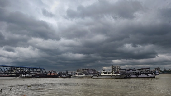 Dark clouds hover in the skies above the boats parked on the bank of Ganga River, as a precautionary measure ahead of the landfall of Cyclone Sitrang, in Kolkata, Monday, October. 24, 2022. (PTI Photo/Swapan Mahapatra)