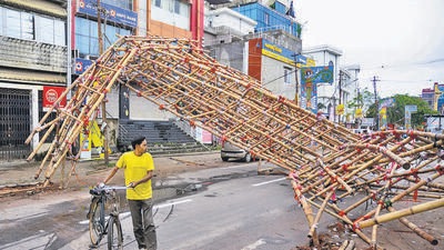 A man walks past a makeshift bamboo gate uprooted amid strong winds, under the impact of Cyclone Sitrang, in Agartala. (ANI) A man walks past a makeshift bamboo gate uprooted amid strong winds, under the impact of Cyclone Sitrang, in Agartala. (ANI)
