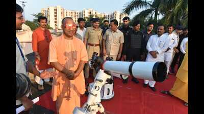 CM Yogi Adityanath, who reached the venue at 4:40 pm, sees the rare celestial event using a telescope. The eclipse was visible in the city for about 52 minutes. (HT)