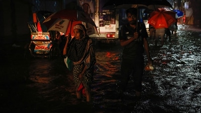 A woman wades through waterlogged streets of Dhaka, Bangladesh. (REUTERS) 