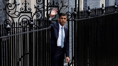 Britain's new Prime Minister Rishi Sunak waves outside 10 Downing Street wearing a sacred Hindu thread on his forearm. (REUTERS)