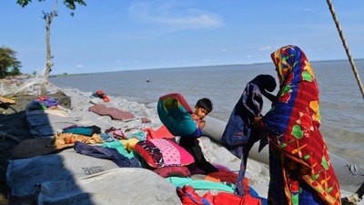A Bangladeshi woman and a child try to salvage their belongings after tropical storm Sitrang lashed the Bay of Bengal coast on Tuesday in Bhola district, Bangladesh. (AP) A Bangladeshi woman and a child try to salvage their belongings after tropical storm Sitrang lashed the Bay of Bengal coast on Tuesday in Bhola district, Bangladesh. (AP)