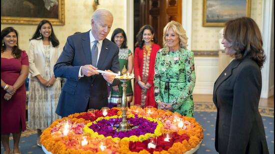 US President Joe Biden lights a lamp as First lady Jill Biden and Vice-President Kamala Harris look on during an event to celebrate Diwali, at the White House in Washington. (PTI)