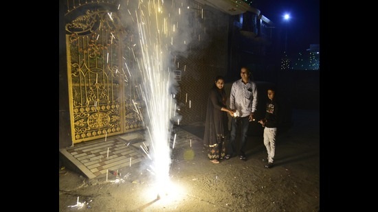 A family watches fireworks on the occasion of Diwali in Amritsar on Monday. (Sameer Sehgal /HT) A family watches fireworks on the occasion of Diwali in Amritsar on Monday. (Sameer Sehgal /HT)