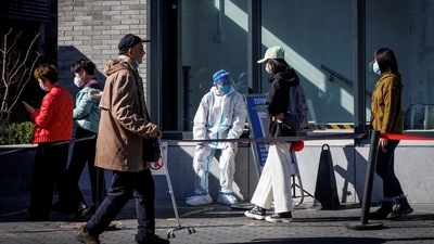 Covid In China: A health worker wears a protective suit near a testing booth. (Reuters)