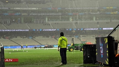 A security official stays in rain as the ICC T20 World Cup 2022 match between New Zealand and Afghanistan being abandoned due to rain in Melbourne. (AFP)
