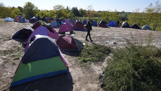 A migrant walks through a makeshift camp near a border line between Serbia and Hungary, near village of Horgos, Serbia. Located at the heart of the so-called Balkan route, Serbia recently has seen a sharp rise in arrivals of migrants passing through the country in search of a better future in the West. (AP Photo/Darko Vojinovic)