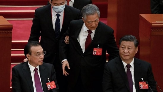 China’s President Xi Jinping (right) sits besides Premier Li Keqiang (left) as former president Hu Jintao (centre) is assisted to leave from the closing ceremony of the 20th China's Communist Party's Congress at the Great Hall of the People in Beijing. (AFP)