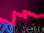 Facebook's new rebrand logo Meta is seen in front of displayed stock graph.