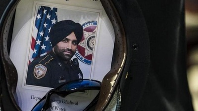 A Houston Police officer places a picture of Harris County Sheriff’s Deputy Sandeep Dhaliwal in his hat. (File) A Houston Police officer places a picture of Harris County Sheriff’s Deputy Sandeep Dhaliwal in his hat. (File)