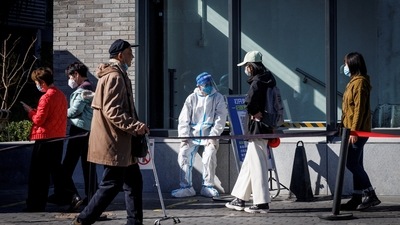 Covid In China: A health worker wears a protective suit near a testing booth. (Reuters)