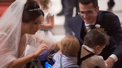Bride and groom interacting with children with down syndrome who were among their ring-bearers. (Twitter/@TheFigen_)