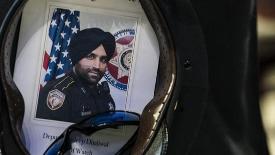 A Houston Police officer places a picture of Harris County Sheriff’s Deputy Sandeep Dhaliwal in his hat.(File)