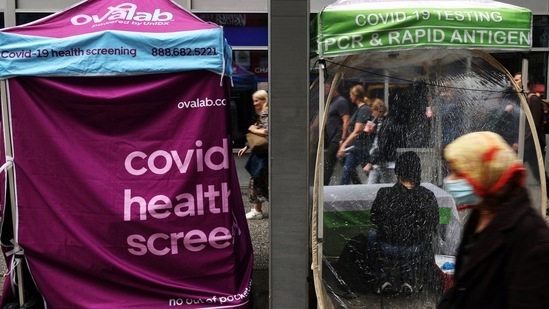 New Covid Wave In Europe: People walk by a mobile coronavirus disease (COVID-19) testing center.(Reuters)