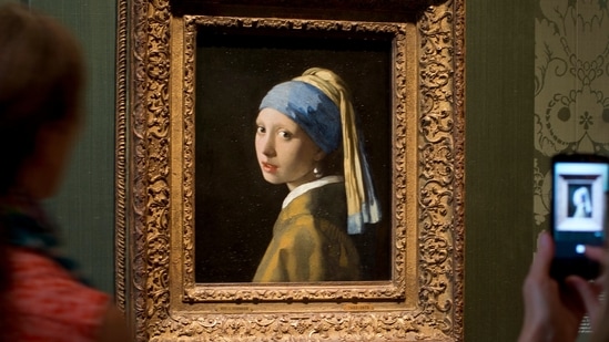 Visitors take pictures of Johannes Vermeer's Girl with a Pearl Earring (AP)