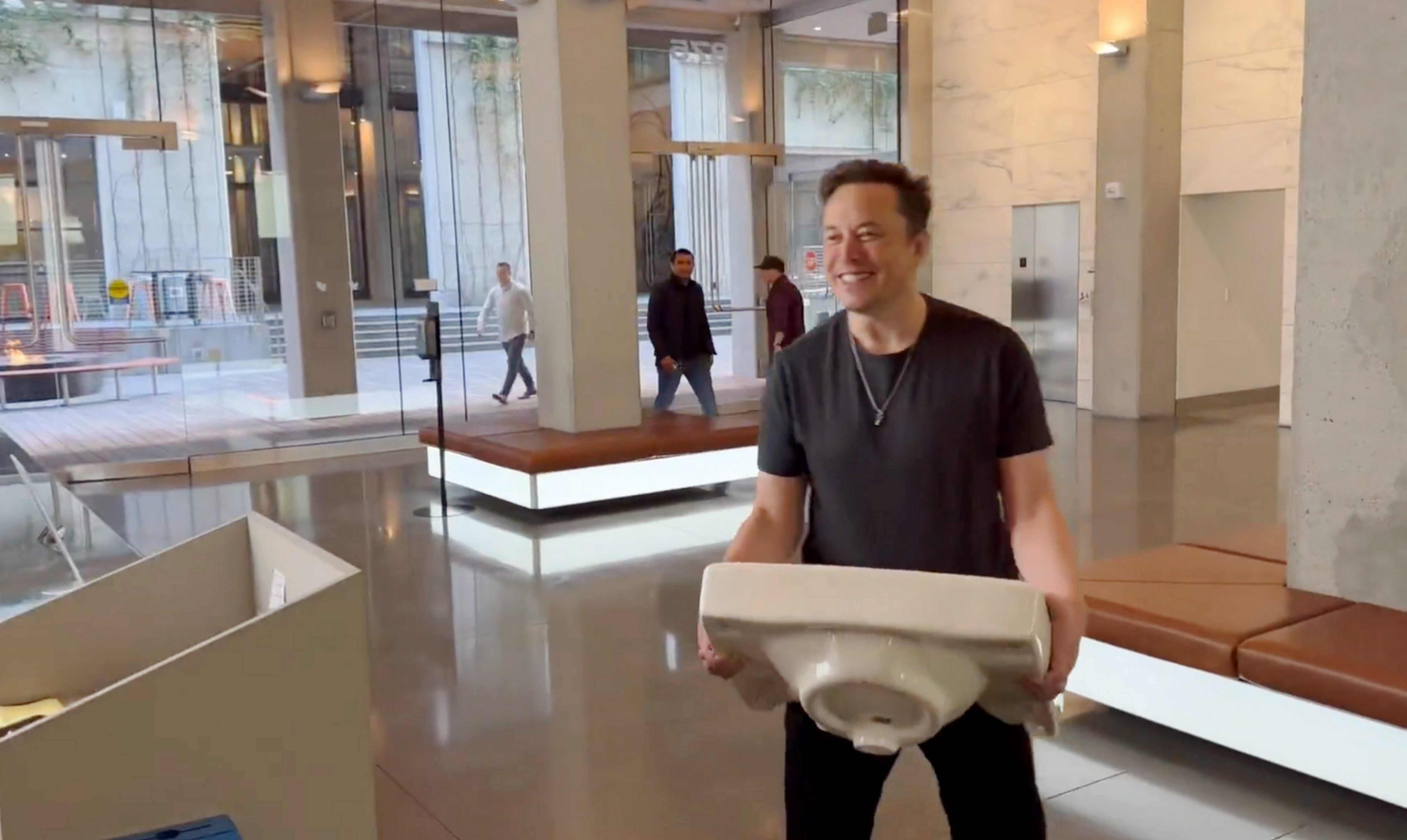 Elon Musk enters the Twitter headquarters carrying a sink through the lobby area, in San Francisco, USA on Thursday. (PTI)