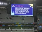 A scoreboard screen displays the announcement that the T20 World Cup cricket match between Australia and England as abandoned due to rain in Melbourne.