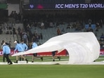 Ground staff place covers over the wicket as rain causes the cancelation of the T20 World Cup cricket match between Australia and England in Melbourne, Australia, Friday, Oct. 28, 2022. 