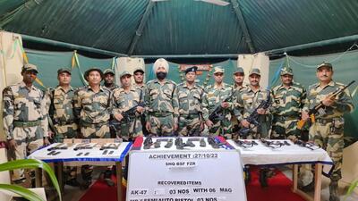 Border Security Force personnel with the arms and ammunition seized from the border area in Ferozepur on Thursday evening. (HT Photo)