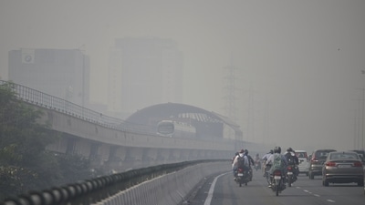 Vehicles and a metro train run on the Delhi-Gurugram Expressway on a smoggy day, in Gurugram on Friday. (ANI Photo) 