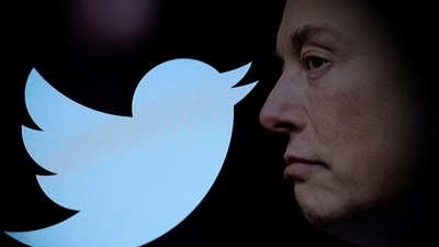 (FILE) Twitter logo and a photo of Elon Musk are displayed through magnifier in this illustration. (REUTERS)