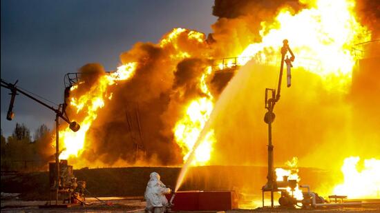 A firefighter works at the site of burning tanks after shelling of an oil depot by Ukrainian forces in Shakhtarsk, Donetsk People’s Republic, eastern Ukraine, on Thursday. (AP)