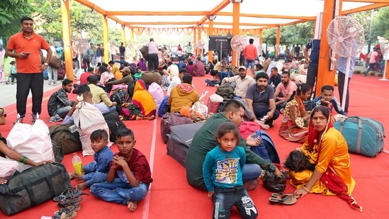 People sit in the waiting area as they wait for their train outside Anand Vihar Terminal ahead of Chhath Puja festival in Delhi on October 27.(ANI)