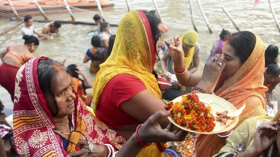 Devotees apply vermillion on each other and offer prayers during the first day of Chhath Puja festival in Patna.(PTI)