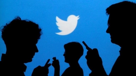 People holding mobile phones are silhouetted against a backdrop projected with the Twitter logo in this illustration picture taken September 27, 2013.(Reuters File Photo)