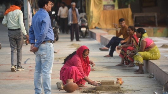 People making preparations for the Chhath puja in Lucknow on Thursday. On the second day of the festival - 'Kharna' - is observed when devotees observe day long fast and break it after worshipping mother Earth in the evening. Offerings made to god include rice pudding (kheer) and fruits. (Deepak Gupta/HT Photo)
