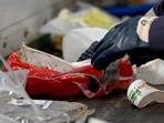 Employee of the Siredom integrated waste treatment centre sorts household waste as it goes through a sorting chain, in a Paris suburb.