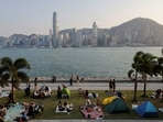 People picnic near the Victoria Harbour during sunset in Hong Kong. China eases strict Covid rules for Table Tennis Tournaments, no quarantine required 