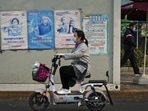 Covid In China: A woman rides past a coronavirus testing facility in Beijing.