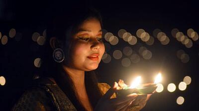 Varanasi, Oct 25 (ANI): A woman lights diyas to celebrate Diwali festival, in Varanasi on Monday. (ANI Photo) (Rajesh Kumar)