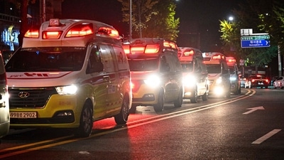 EDITORS NOTE: Graphic content / Ambulances line the road in the neighbourhood of Itaewon in Seoul on October 30, 2022, after a Halloween stampede took place. - More than 140 people were killed on October 29 and some 150 were injured in a horrific stampede in central Seoul when a large crowd celebrating Halloween crammed into a narrow street, officials said. (Photo by Anthony WALLACE / AFP) (AFP) EDITORS NOTE: Graphic content / Ambulances line the road in the neighbourhood of Itaewon in Seoul on October 30, 2022, after a Halloween stampede took place. - More than 140 people were killed on October 29 and some 150 were injured in a horrific stampede in central Seoul when a large crowd celebrating Halloween crammed into a narrow street, officials said. (Photo by Anthony WALLACE / AFP) (AFP)