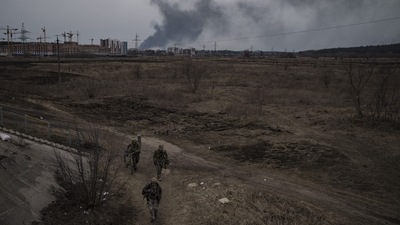 Russia-Ukraine War: Soldiers walk on a path as smoke billows from the town of Irpin. (AP)