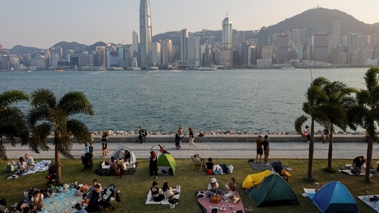 People picnic near the Victoria Harbour during sunset in Hong Kong. China eases strict Covid rules for Table Tennis Tournaments, no quarantine required (REUTERS/Tyrone Siu)