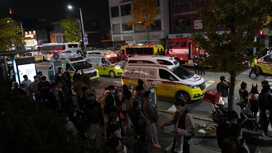 Ambulances carrying victims head to the hospital near the scene in Seoul, South Korea, Sunday, Oct. 30, 2022. At least 146 people were killed and 100 more were injured as they were crushed by a large crowd pushing forward on a narrow street during Halloween festivities in the capital of Seoul, South Korean officials said. (AP Photo/Lee Jin-man)