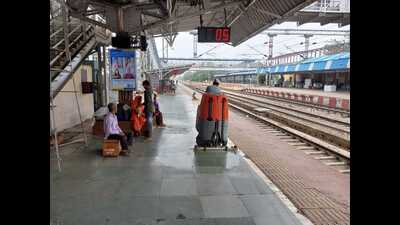 A railway employee busy cleaning a platform using a scrubber machine at a railway station of NCR. (HT Photo)