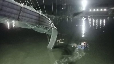 Rescue operation underway after an old suspension bridge over Machchhu river collapsed in Gujarat’s Morbi district on Sunday. (PTI) Rescue operation underway after an old suspension bridge over Machchhu river collapsed in Gujarat’s Morbi district on Sunday. (PTI)