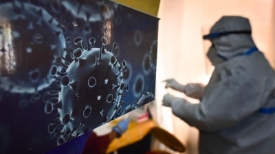 An illustration of the novel coronavirus seen next to a health care worker at a Covid-19 testing centre in New Delhi. (File image) An illustration of the novel coronavirus seen next to a health care worker at a Covid-19 testing centre in New Delhi. (File image)