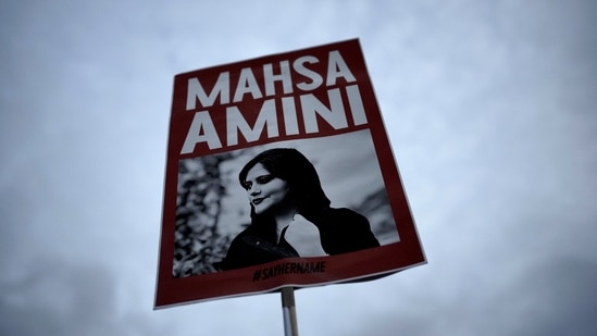 Iran Anti-Hijab Protests: A woman holds a placard with a picture of Iranian woman Mahsa Amini during a protest against her death.(AP)