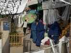 Afghan burqa-clad women walk amid a market. Afghan burqa-clad women walk amid a market.