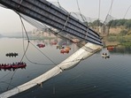 Rescue personnel conduct search operations after a bridge across the river Machchhu collapsed at Morbi in Gujarat. (AFP) Rescue personnel conduct search operations after a bridge across the river Machchhu collapsed at Morbi in Gujarat. (AFP)