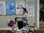 Covid In Shanghai: A woman rides past a coronavirus testing facility.