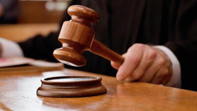 Judge holding gavel in courtroom (Getty Images/OJO Images RF)