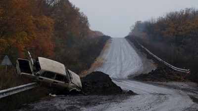 A destroyed car is seen on a road as Russia's invasion of Ukraine continues. (REUTERS)