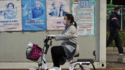 Covid In Shanghai: A woman rides past a coronavirus testing facility. (AP)