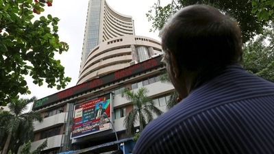 A man looks at a screen across a road displaying the Sensex on the facade of the Bombay Stock Exchange (BSE) building in Mumbai. (REUTERS)